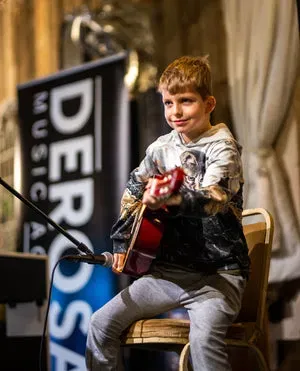 A young DeRosa student performing guitar
